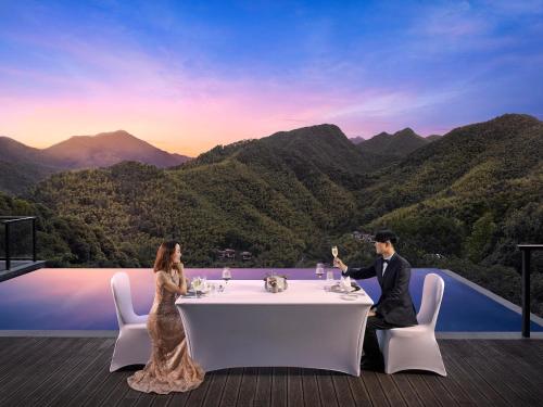 a bride and groom sitting at a table on a deck at AHN LAN Ninghai in Ninghai