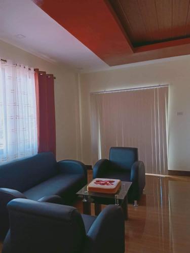 a living room with two blue couches and a coffee table at Villa Cresenciana in Batuan