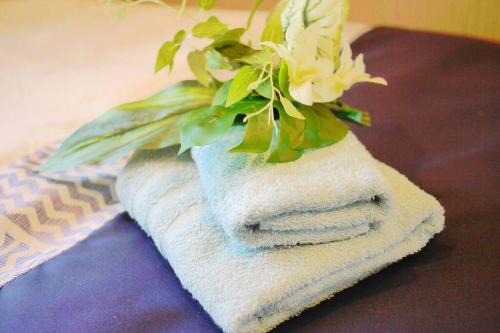 a pile of towels with a plant on top at Ocean Resort 101 in Shioya
