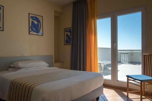 - une chambre avec un lit et une porte coulissante en verre dans l'établissement Hotel Ping Pong, à Lido di Ostia