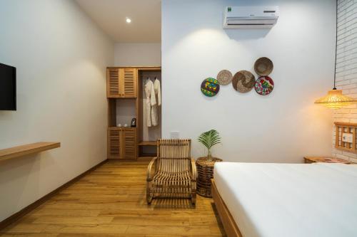 a bedroom with a bed and a chair at Hoi An Gravel Pool Villa & Spa in Hoi An