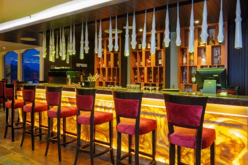 a bar with red stools in a restaurant at Ramada by Wyndham Kathmandu Dhumbarahi in Kathmandu