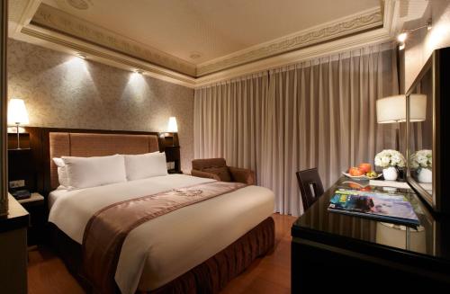 a hotel room with a large bed and a desk at Deja Vu Hotel in Taipei