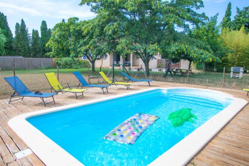 uma piscina com cadeiras e um flutuador na água em Villa à la campagne em Camélas