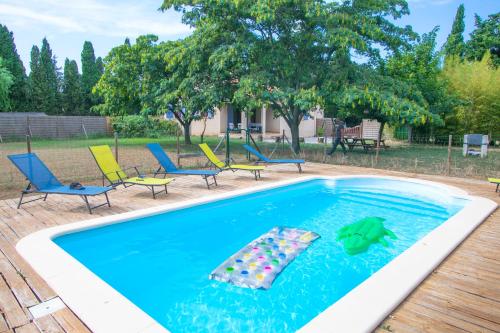 a swimming pool with chairs and a float in the water at Villa à la campagne in Camélas