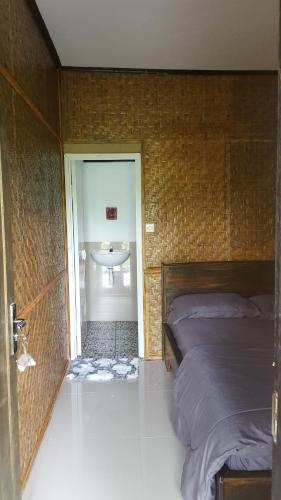 a bedroom with a bed and a bathroom with a sink at Tetebatu Indah Homestay in Tetebatu