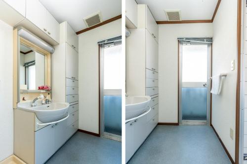 a bathroom with two sinks and a mirror at Asuka Hotel in Karatsu