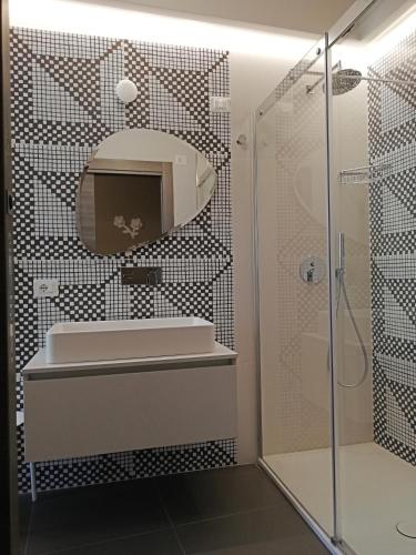 a bathroom with a shower and a sink and a mirror at Ciclope Resort in Acitrezza