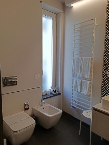 a bathroom with a sink and a toilet and a window at Ciclope Resort in Acitrezza