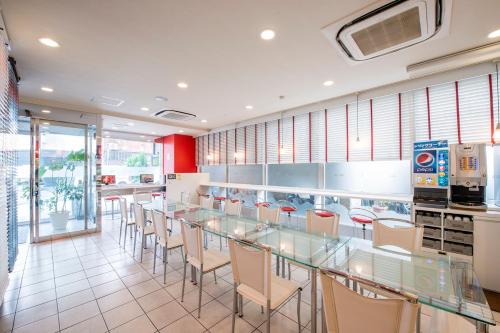 a restaurant with a long glass table and chairs at Sejour Inn Nagarekawa in Hiroshima