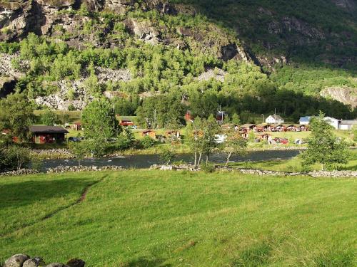 a green field with a village in the mountains at Lunde Camping in Aurland