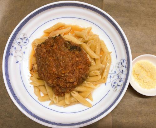 a plate of pasta with meat sauce and a bowl of sauce at Poolside Villa in Phnom Penh