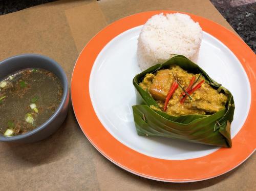 a plate of food with rice and a bowl of soup at Poolside Villa in Phnom Penh