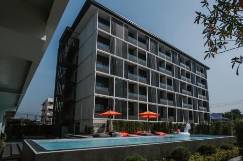 a hotel with a pool in front of a building at The Iconic Hotel Don Mueang Airport in Bangkok