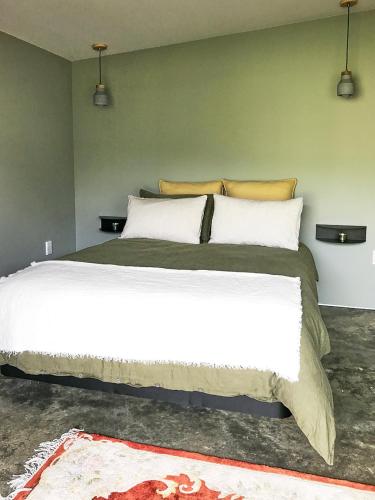 a bedroom with a large white bed in a room at Studio 40 in Coromandel Town