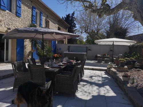 a patio with a table and chairs and an umbrella at MAS PROVENCAL A FLANC DE COLLINE in Bollène