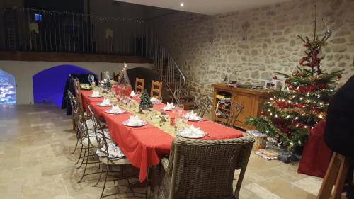 a long table in a room with a christmas tree at MAS PROVENCAL A FLANC DE COLLINE in Bollène