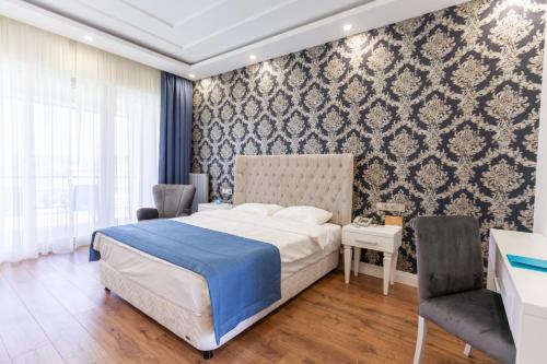 a bedroom with a bed and two chairs and a table at Ankara Vilayetler Evi in Golbası