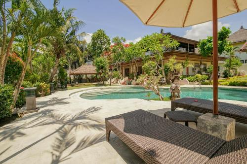 an outdoor patio with a pool and a house at Baliana Villa Legian in Legian