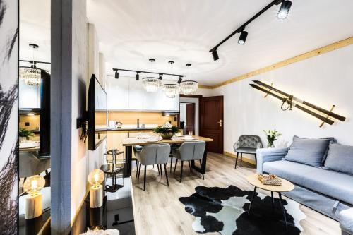 ein Wohnzimmer mit einem blauen Sofa und einem Tisch in der Unterkunft Apartament SKI in Zakopane