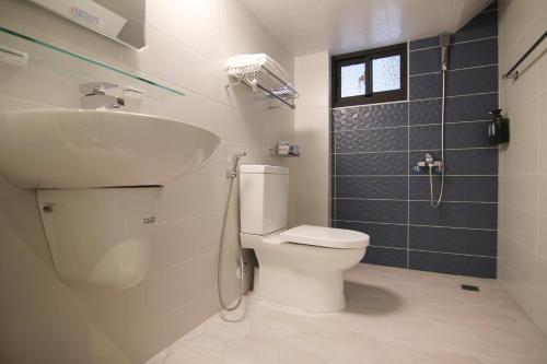 a bathroom with a toilet and a sink and a shower at Haichin&Haiting B&B in Donggang