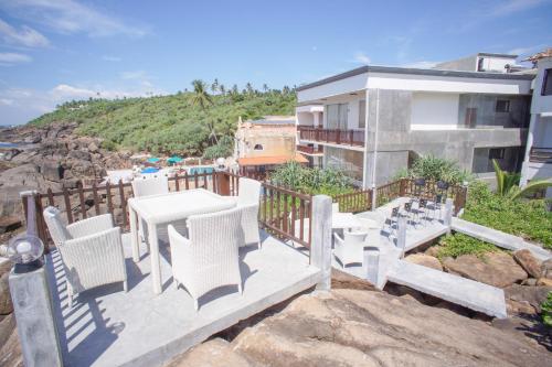 a balcony with a table and chairs and a building at Hotel Zeilan Sunset Point in Unawatuna