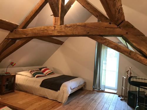 a bedroom with a bed in the attic at Les Marguerites in Palinges