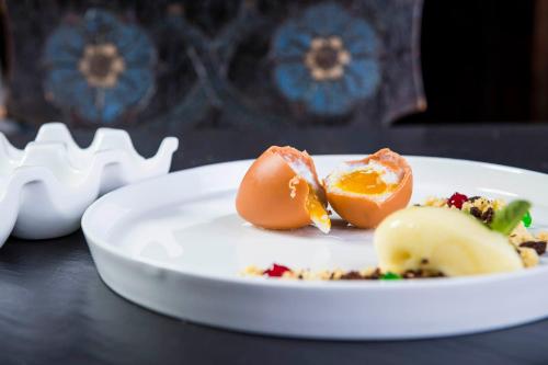 a white plate with an egg on a table at Romantik Hotel & Restaurant Stafler in Vipiteno