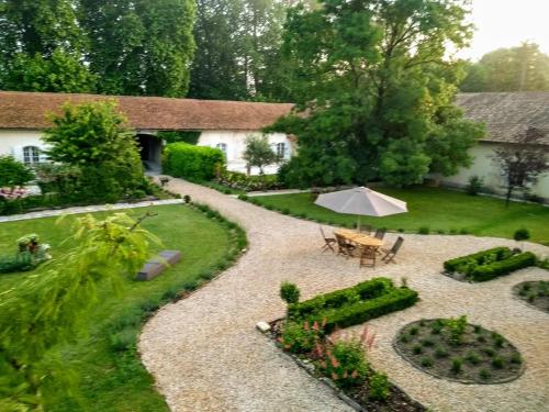 a garden with an umbrella and a table and chairs at Le Domaine Des Platanes in Bourg-Charente