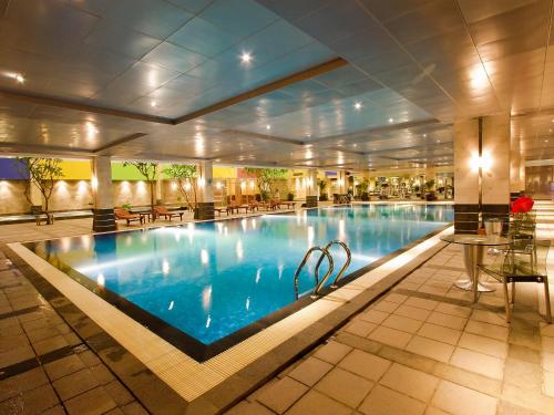 a large swimming pool in a hotel lobby at FM7 Resort Hotel - Jakarta Airport in Tangerang