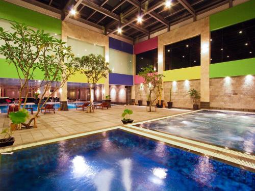 une grande piscine dans un bâtiment avec des plantes dans l'établissement FM7 Resort Hotel - Jakarta Airport, à Tangerang