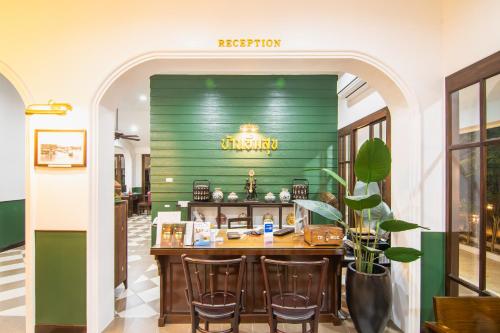 a restaurant with a green wall and a table at Baan Imm Sook Resort in Chao Lao Beach