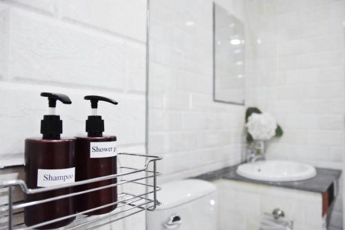 a bathroom with a sink and two bottles of shampoo at B and Y Residence in Chiang Mai