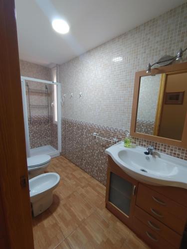 a bathroom with a sink and a toilet and a mirror at Apartamento Maravillas in Caravaca de la Cruz