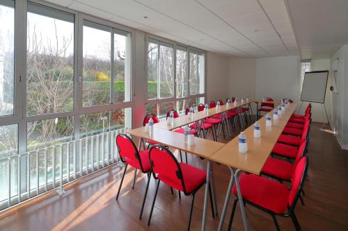 a conference room with a long table and red chairs at Hotel CIS Paris Kellermann in Paris
