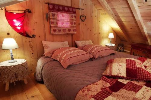 a bedroom with a bed in a log cabin at Au petit chalet avec son SPA - Escapade en amoureux ! in Cruet