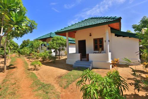 a small house in the middle of a field at Paper Moon Kudils in Arugam Bay