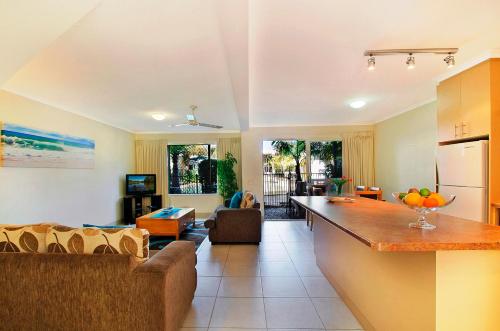 a living room with a couch and a kitchen at Ivory Palms Resort Noosa in Noosaville