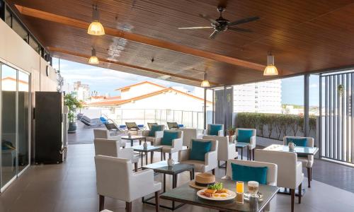 a restaurant with tables and chairs on a balcony at Travelodge Pattaya in Pattaya