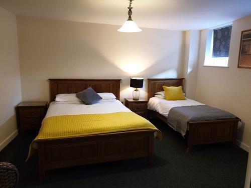 a bedroom with two beds with yellow sheets at The Dorrington in Halstead