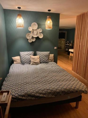 une chambre avec un grand lit aux murs bleus dans l'établissement L ABRI spa et détente, à Liergues