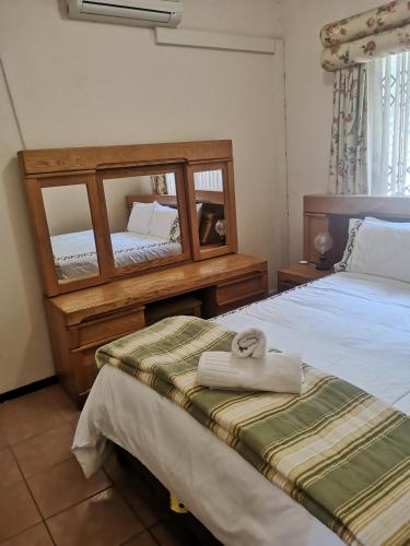 a hotel room with two beds and a mirror at 26 Isikhulu in Umdloti