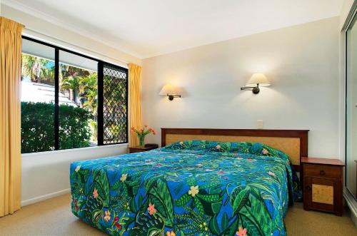 a bedroom with a bed and a large window at Ivory Palms Resort Noosa in Noosaville