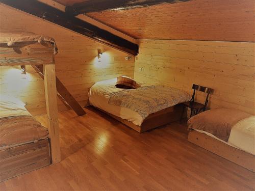 a room with two beds in a log cabin at L'Ours Blanc in La Féclaz