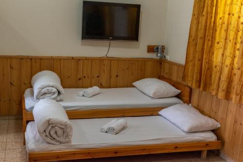 a room with two bunk beds and a flat screen tv at "Bakfar" Kfar Szold Country Lodging in Kefar Szold