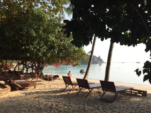a beach with chairs and people on the water at Big Fish Resort Koh Tao in Koh Tao