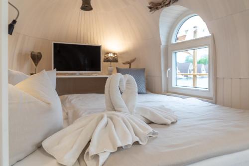 a white bedroom with a large white bed with a window at Panorama Iglu Romantik & Family in Parey