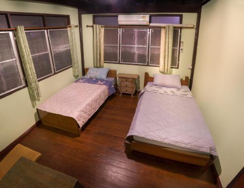 two beds in a room with two windows at Yesterday Sathon in Bangkok
