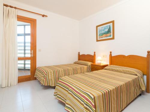twee bedden in een kamer met een raam bij Voramar 2f in Port de Pollença