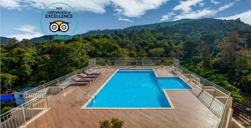 a swimming pool on top of a building with a mountain at Sterling Thekkady in Thekkady
